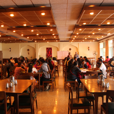 ETST 1 People sitting on different tables in a room