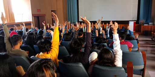 Participants raising hands in the auditorium