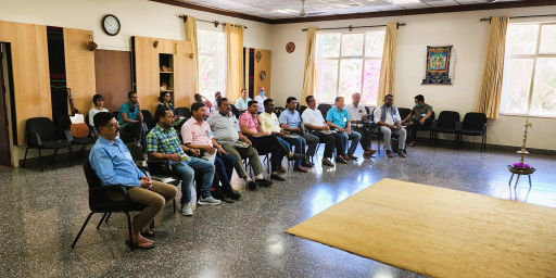 A group of people sitting in a semi circle in a room