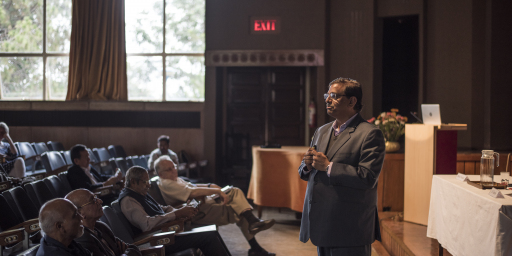 A speaker addressing a group of people